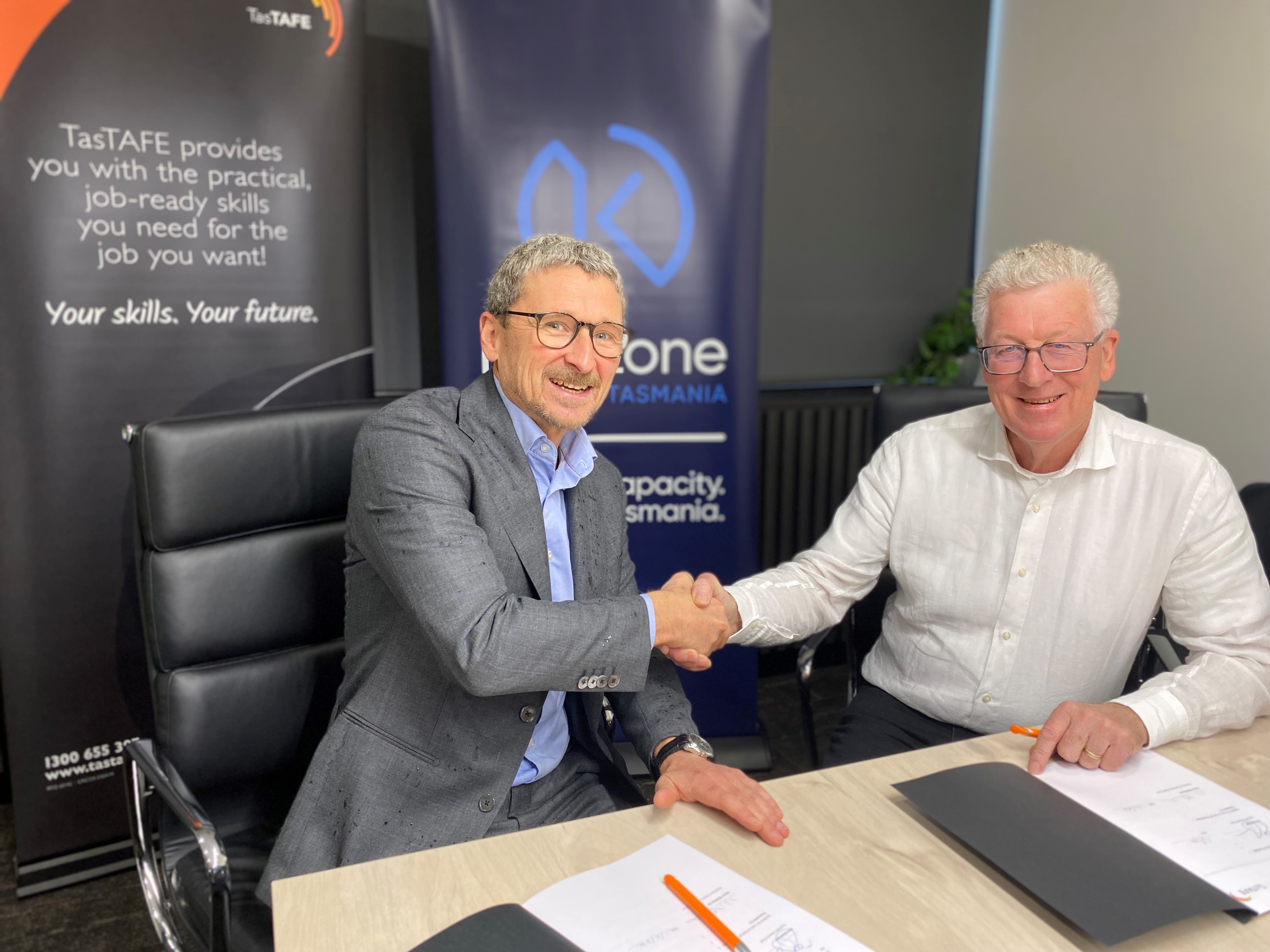 Tim Gardner and Norm Mcilfatrick pose for a photo sitting at a table 