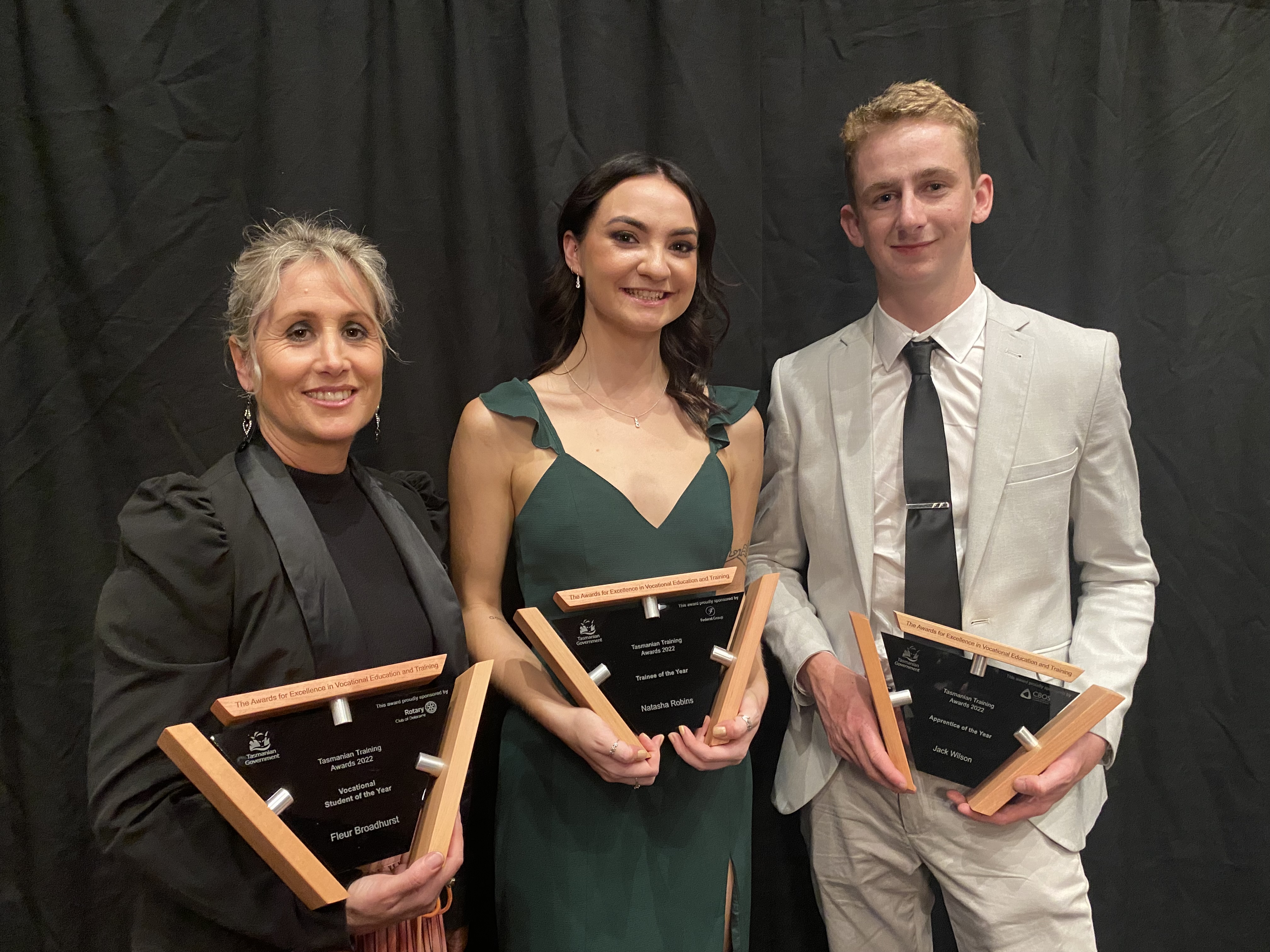 3 TasTAFE students holding their Tasmania training awards trophies