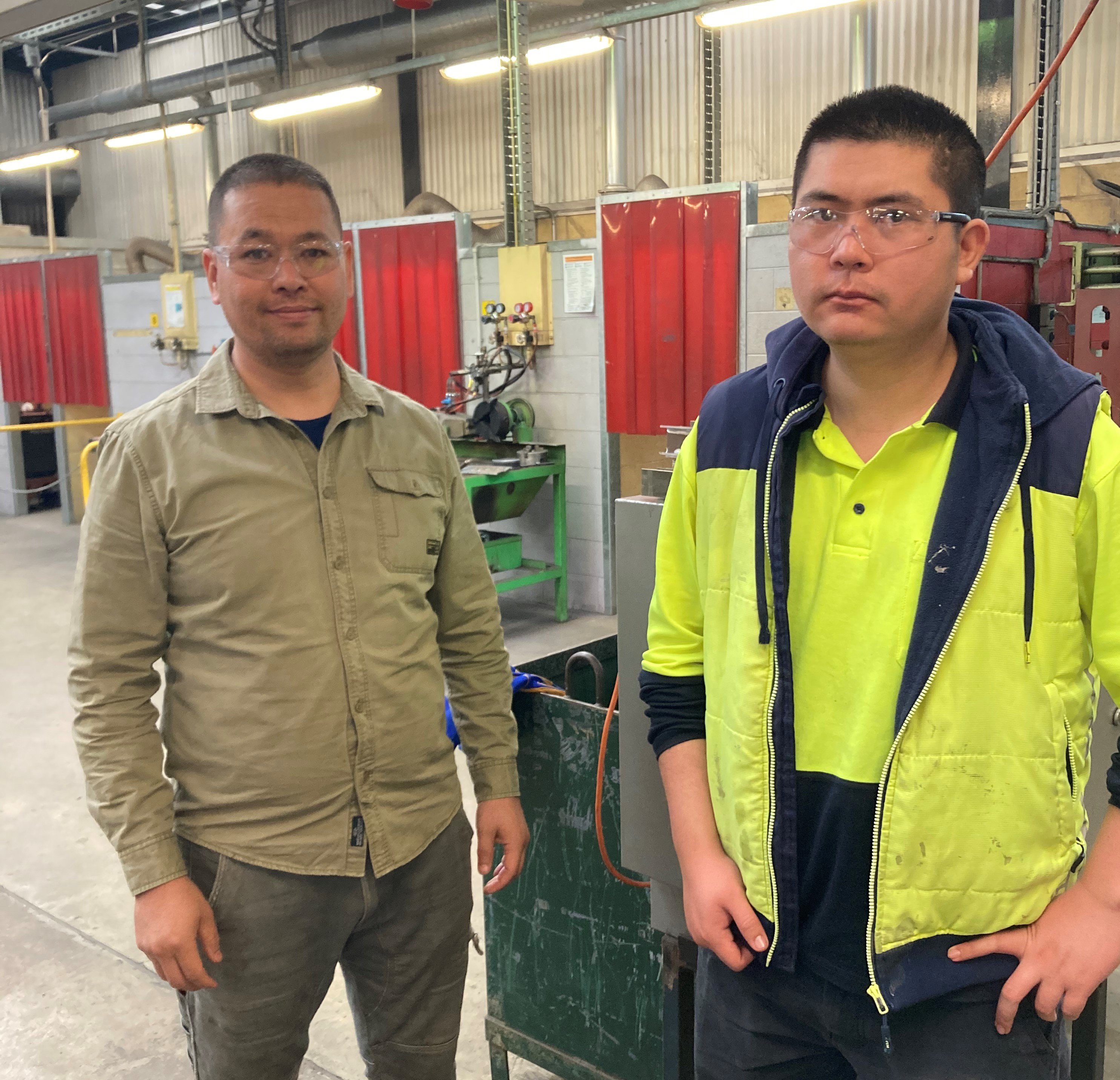 Two people in workshop wearing safety glasses