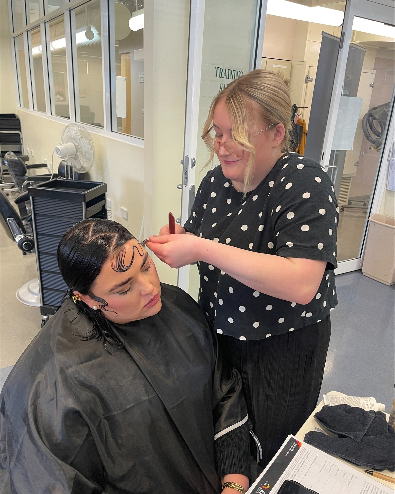 Hairdresser cuts a woman's hair
