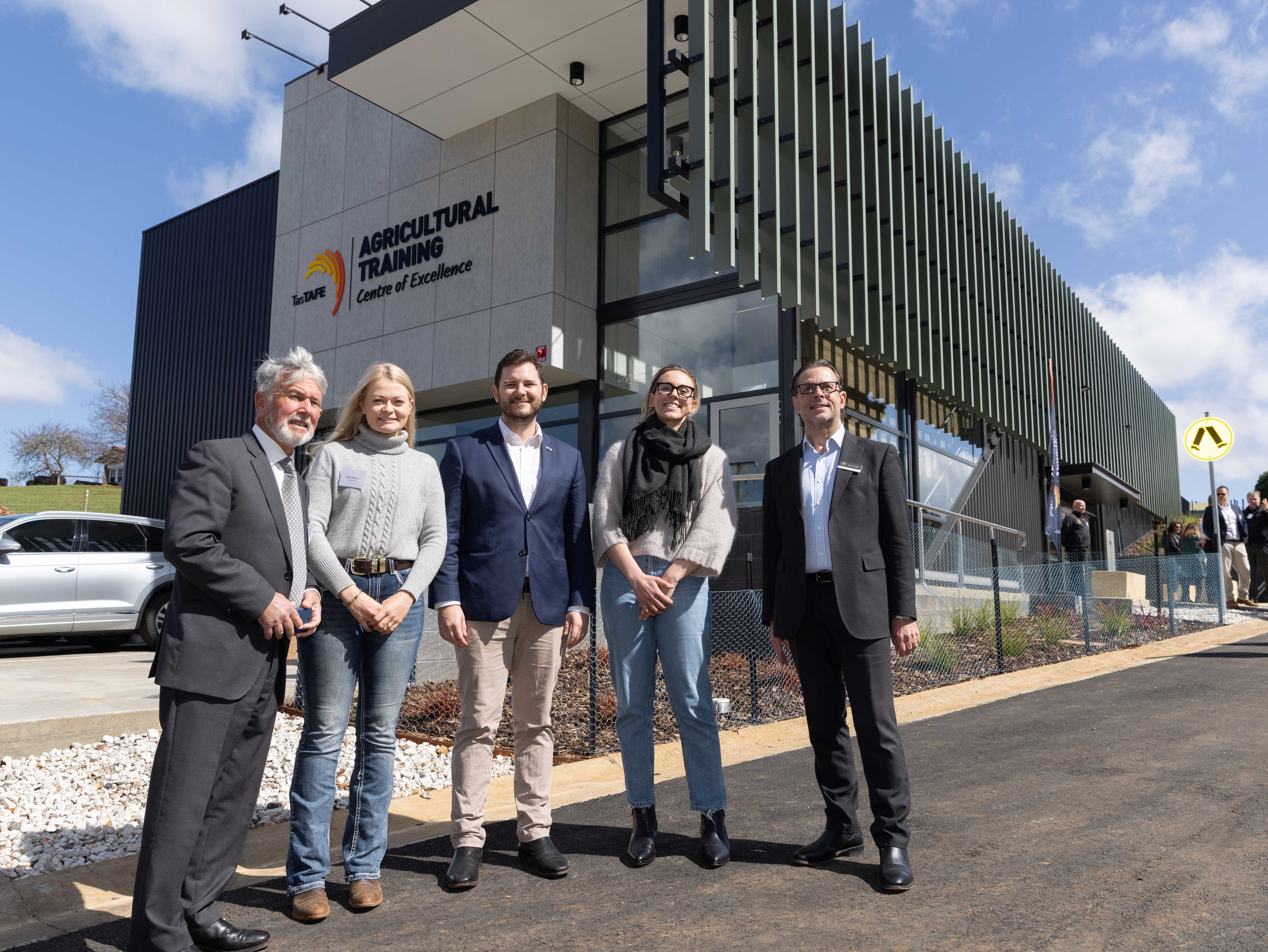 5 people standing in frornt of the Agricultural training facility building