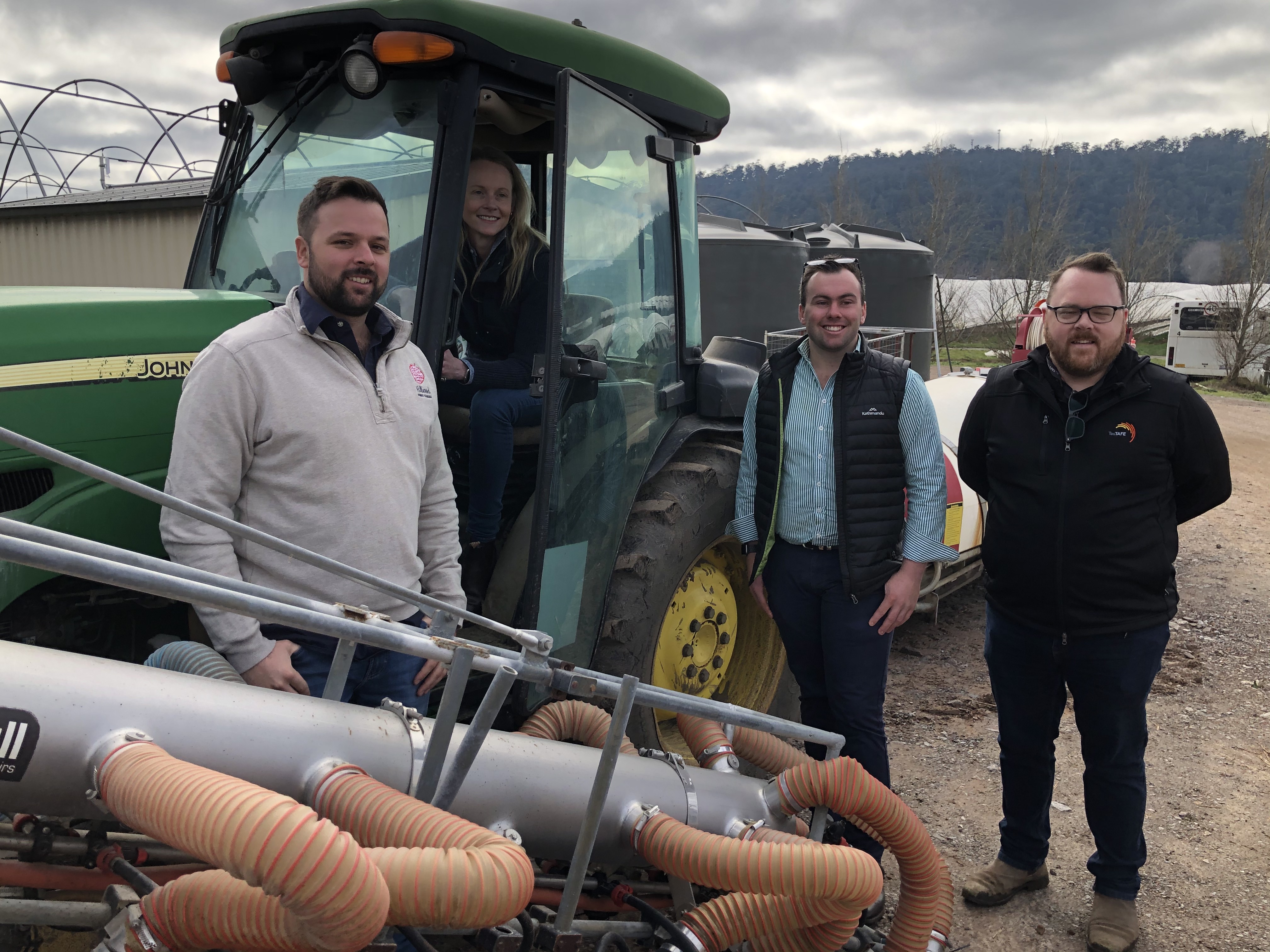 Minister Sarah Courtney poses in a tractor with others nearby