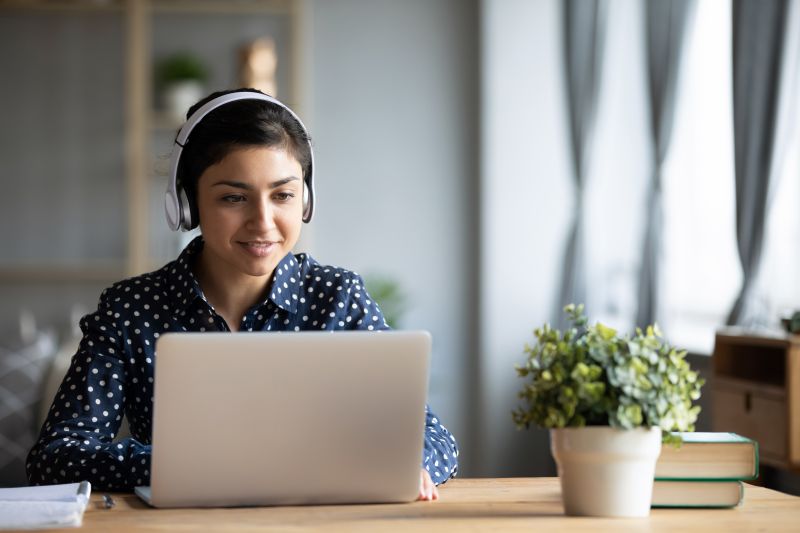 Person sitting at a laptop with headphones on