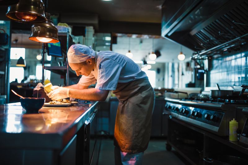 Chef dressing a plate in the kitchen