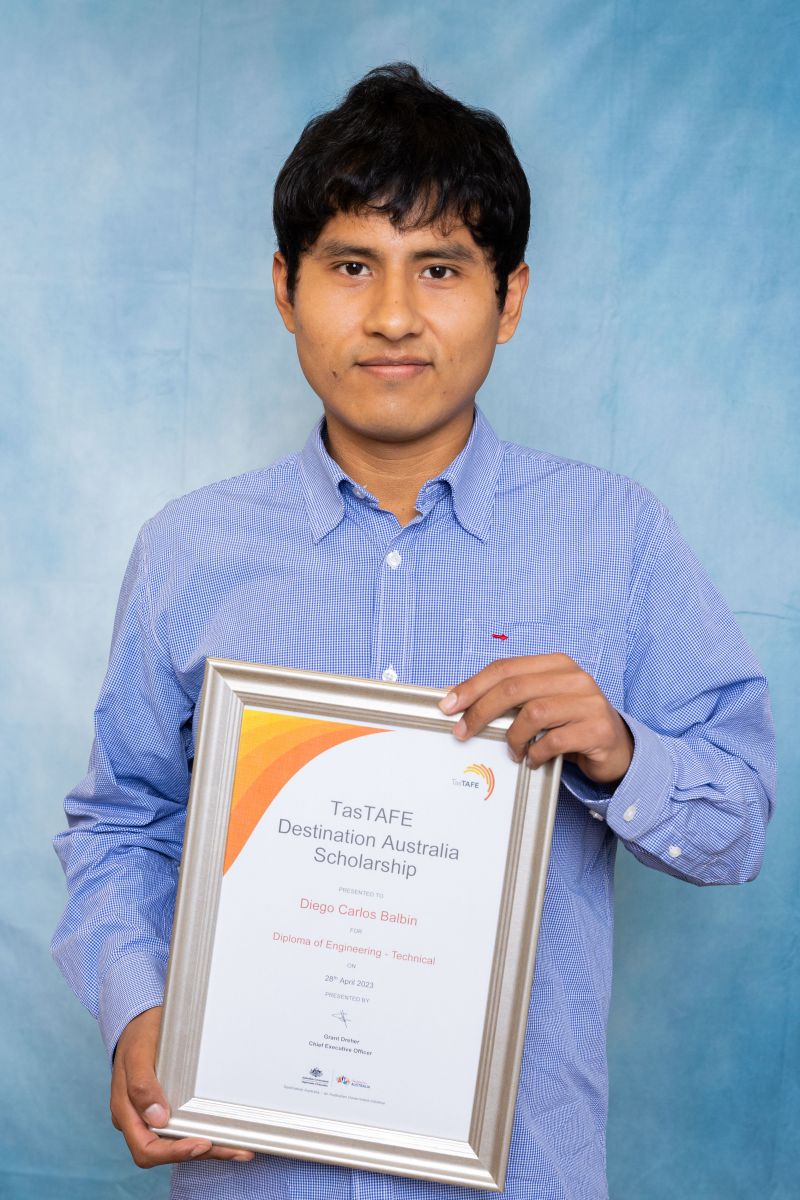 Man poses with his Destination Australia scholarship certificate