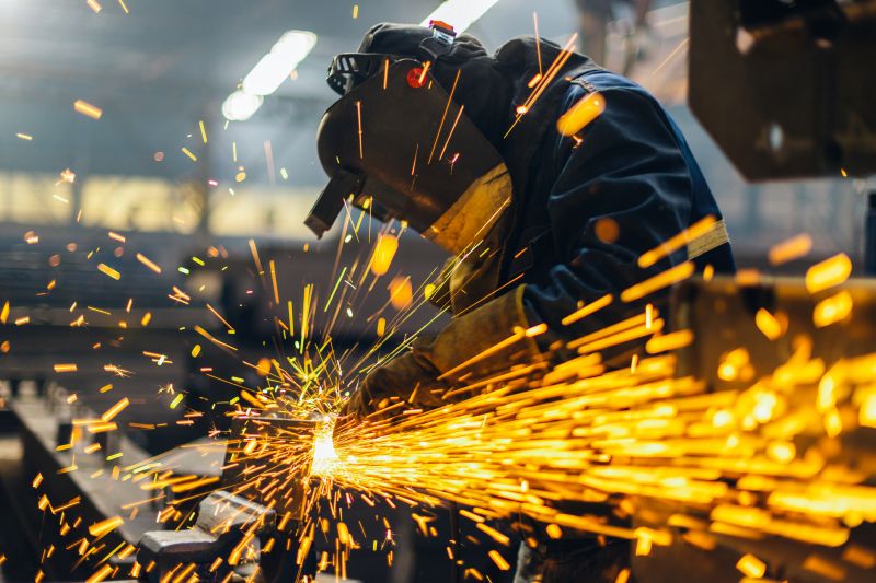 Welder with a face shield welding some metal