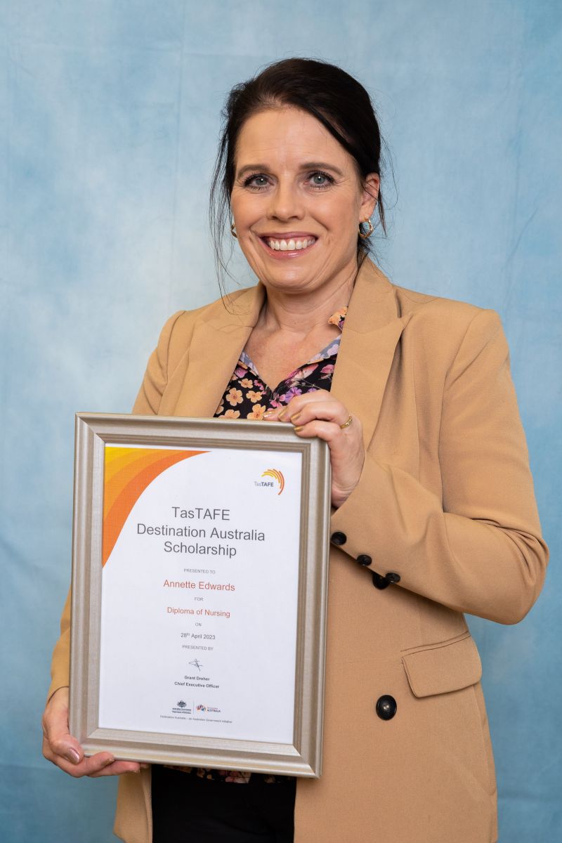 Woman poses with her Destination Australia scholarship certificate