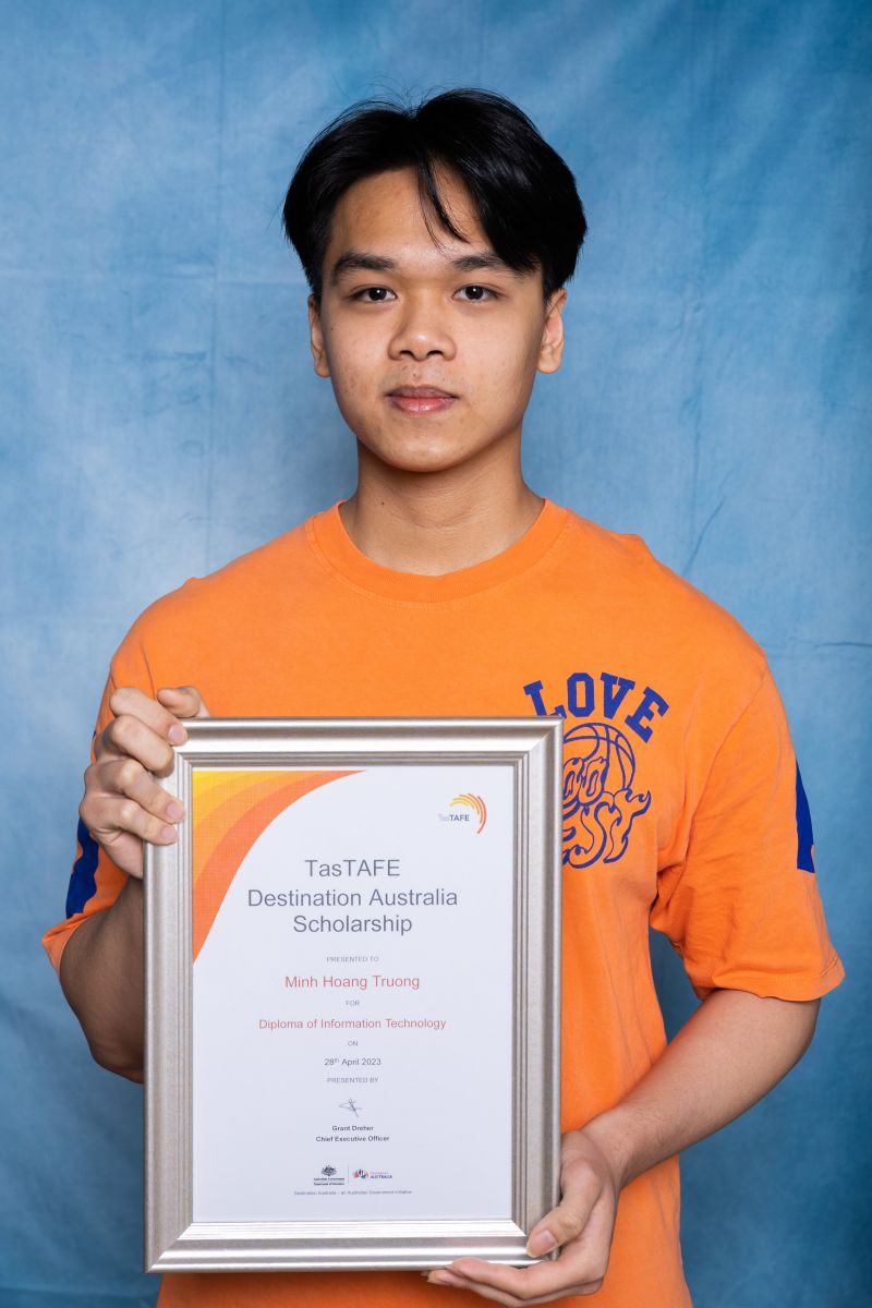  Man poses with his Destination Australia scholarship certificate