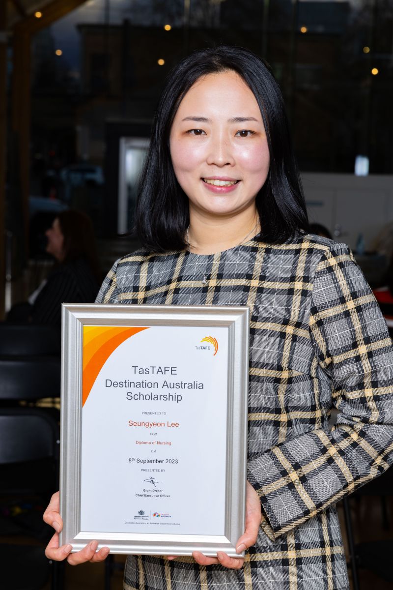 Woman holding a framed certificate