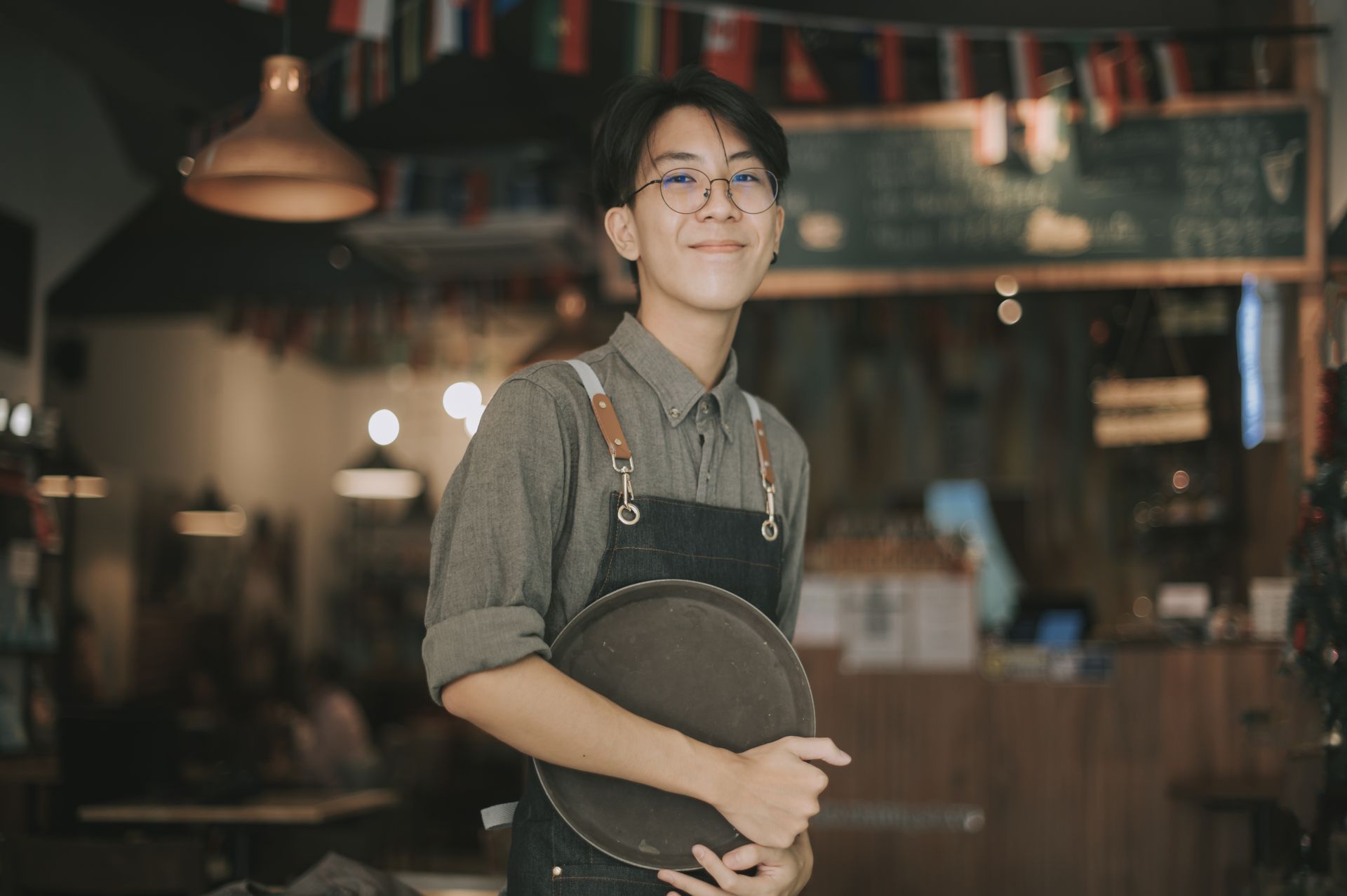 Man holding a serving plate in front of the bar
