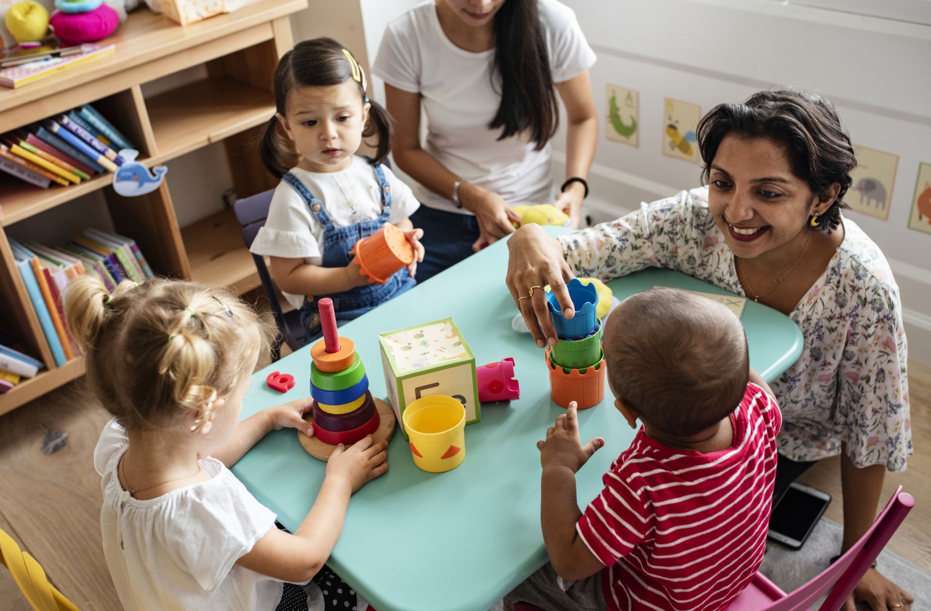 Early education teacher playing with Kids at the table 