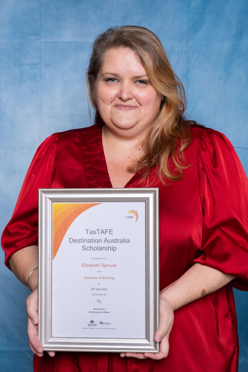 Woman poses with her Destination Australia scholarship certificate