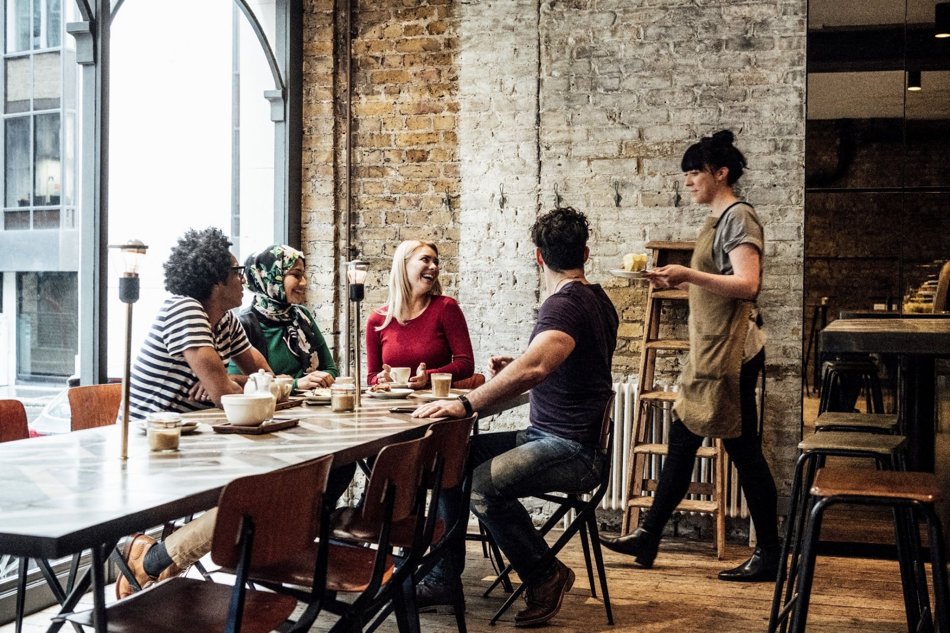 Group of people sitting at a table in a cafe