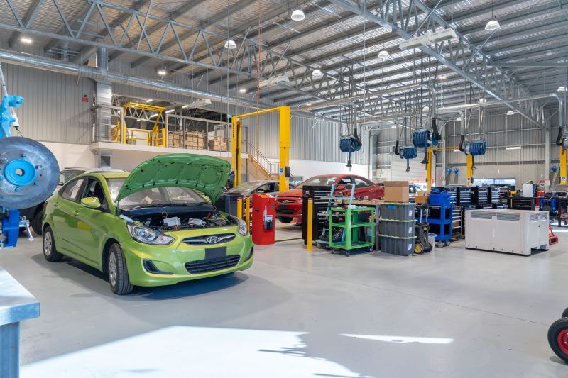 Inside of the new TasTAFE Automotive Training facility. Cars, work benches and machinery inside a warehouse.