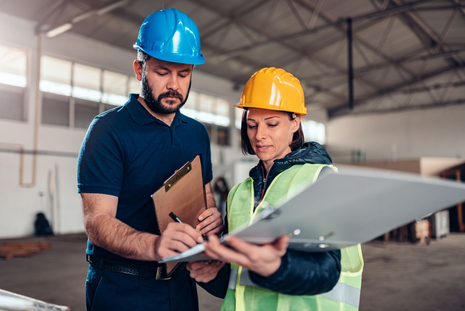 Man and woman stading looking at a clipboard in a warehouse