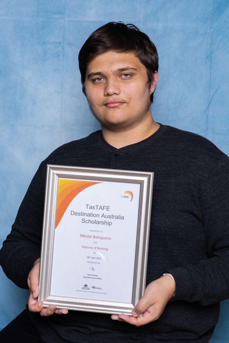 Man poses with his Destination Australia scholarship certificate