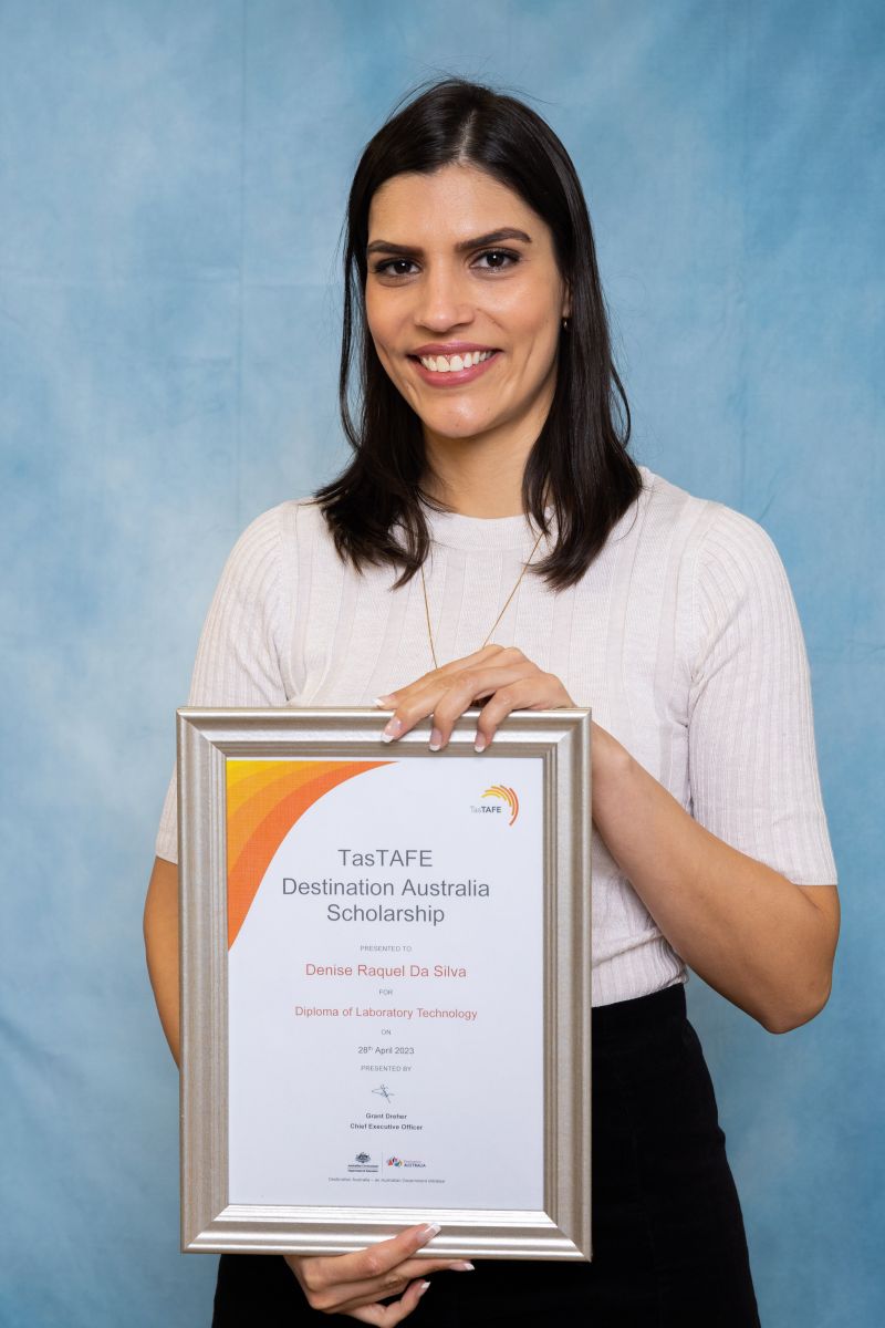 Woman poses with her Destination Australia scholarship certificate