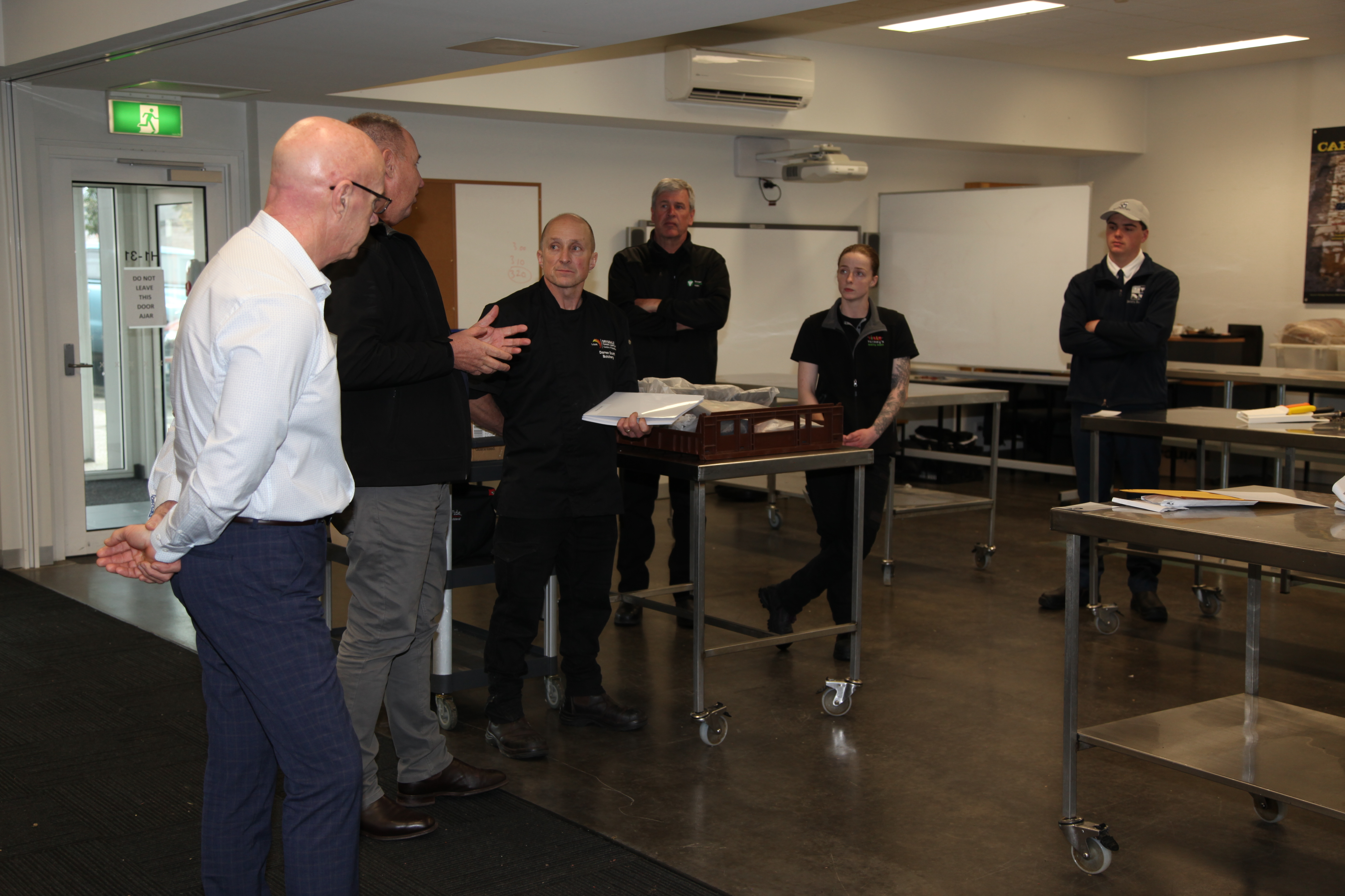 Group of people talking in the butchery classroom