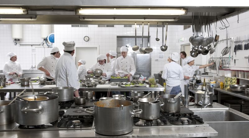 Students and teacher in the kitchen preparing food 