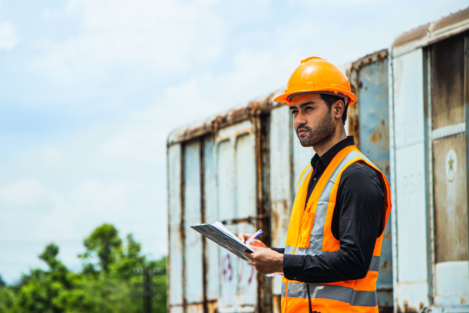 Man holding a workbook outdoors 