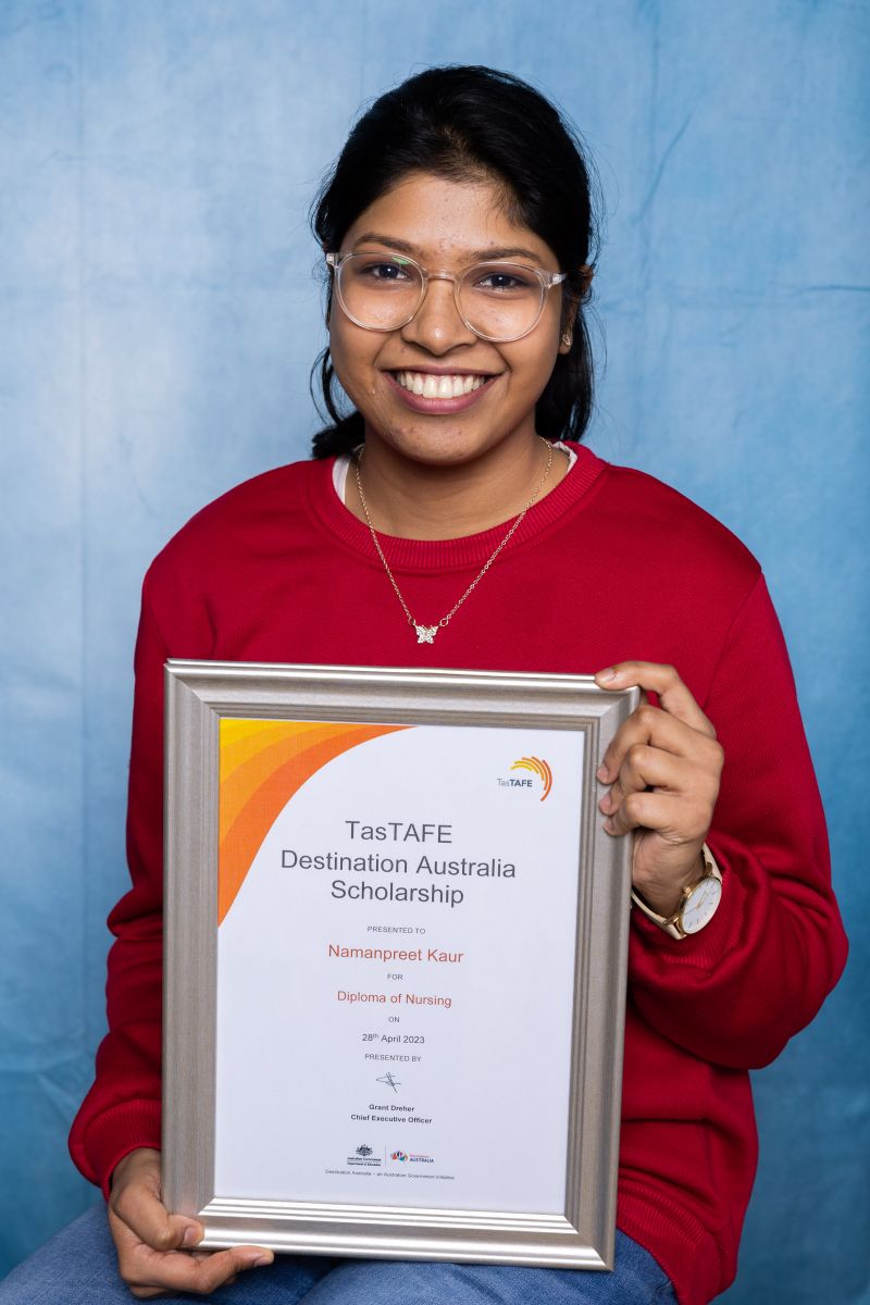 Woman poses with her Destination Australia scholarship certificate