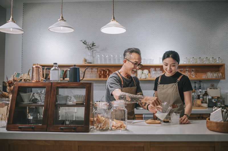 Man and woman at counter of a coffee shop pouring a drink