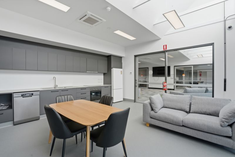 A fully equipped kitchen with dining table tables and chairs and a couch.