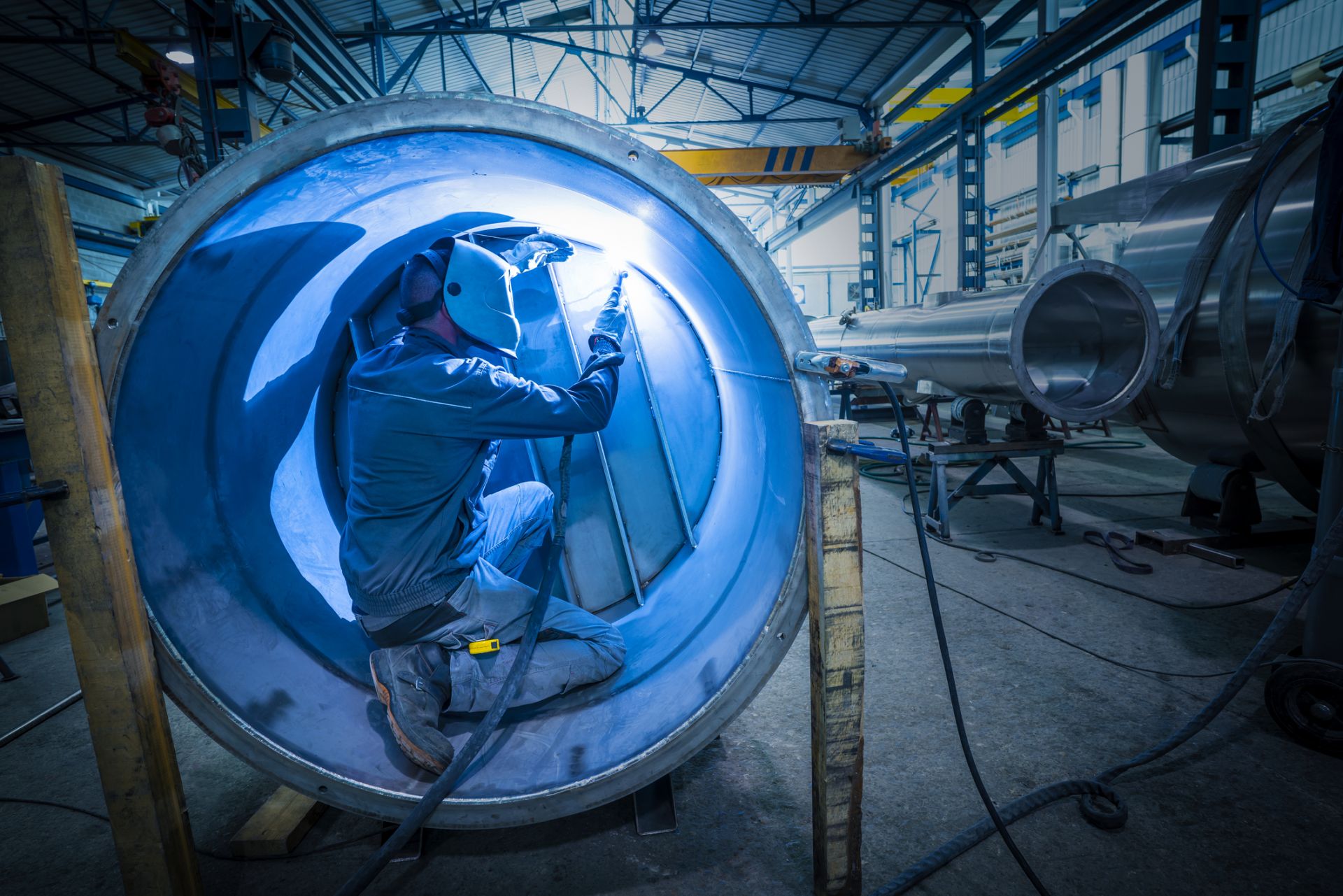 Man welding the inside of a large boiler