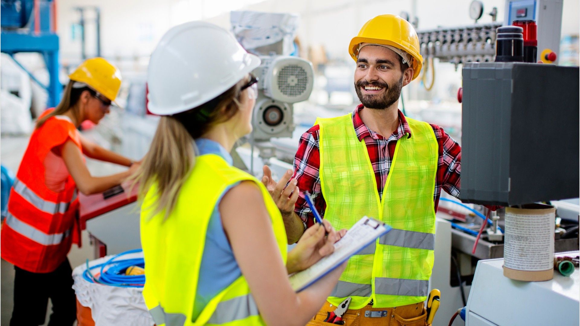 man and woman in the workshop in hi-vis vests 