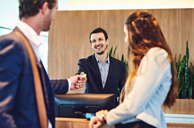 Reception handing over a card to customers
